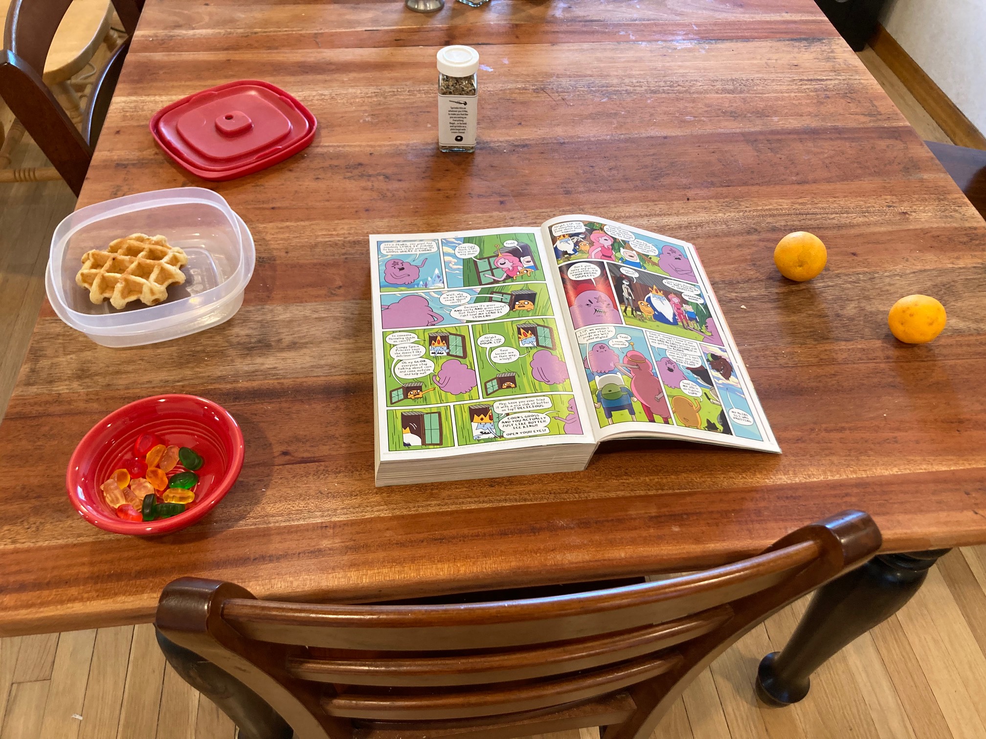 Waffle, gummy bears, tangerines, book on table